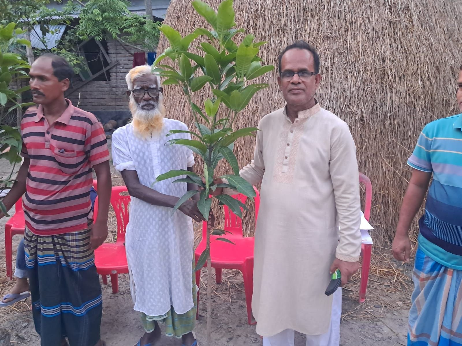প্রবীণ এলাকাবাসীর হাতে গাছের চারা তুলে দেওয়া হচ্ছে